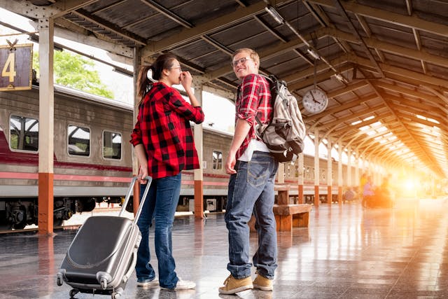  homme-et-femme-en-chemises-de-flanelle-rouge-au-train sur quai de gare 